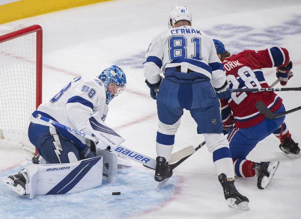 Slovenský obranca Tampy Bay Lightning Erik Černák (uprostred), brankár Tampy Andrij Vasilevskij (vľavo) a hráč Montrealu Canadiens Christian Dvorak (vpravo) počas zápasu zámorskej hokejovej NHL Tampa Bay Lightning - Montreal Canadiens