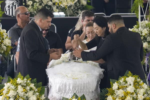Marcia Aokiová, vdova po zosnulom brazílskom futbalovom velikánovi Pelém, drží ruženec nad jeho telom.