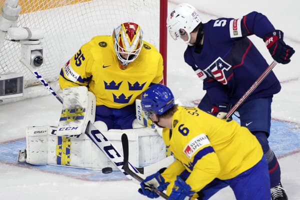 Švédsky brankár Carl Lindbom(vľavo), hráč USA Rutger McGroarty (uprostred) a hokejista Švédska Victor Sjöholm v zápase o 3. miesto Švédsko - USA na MS hráčov do 20 rokov.
