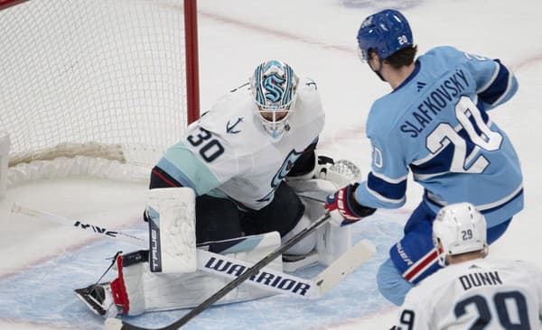 Slovenský hokejista Montrealu Canadiens Juraj Slafkovský (uprostred) a brankár Seattle Kraken Martin Jones počas zápasu zámorskej NHL.