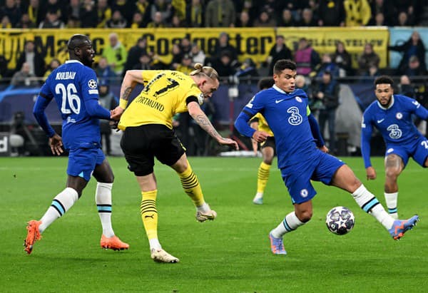 Hráč Dortmundu Marius Wolf(uprostred) kope do lopty cez Thiagu Silva z Chelsea vo futbalovom zápase osemfinále Ligy majstrov