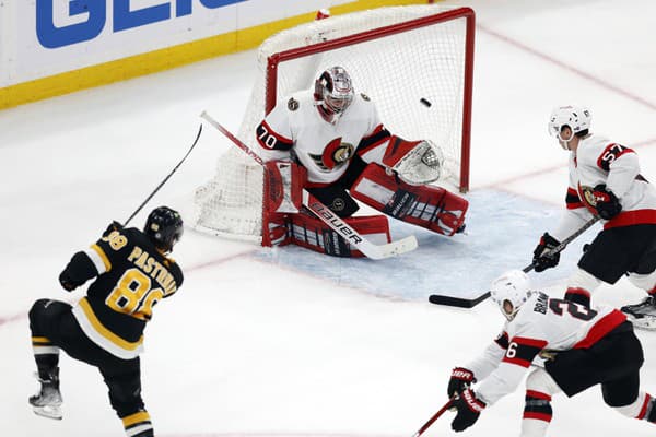 Hokejista Bostonu Bruins David Pastrňák (vľavo) strieľa gól v zápase zámorskej hokejovej NHL Boston Bruins - Ottawa Senators.