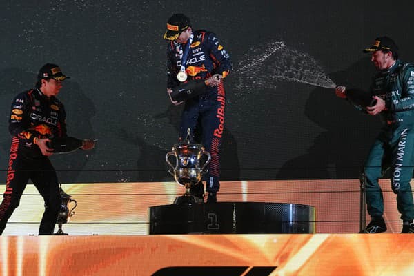 Na snímke uprostred Holanďan Max Verstappen z tímu Red Bull oslavuje na pódiu po víťazstve na Veľkej cene Bahrajnu, úvodných pretekoch seriálu MS F1 v sezóne 2023 na okruhu Sachír v nedeľu 5. marca 2023. Vľavo druhý a jeho tímový kolega z Mexika Sergio Perez, vpravo tretí  Španiel Fernando Alonso z tímu Aston Martin.