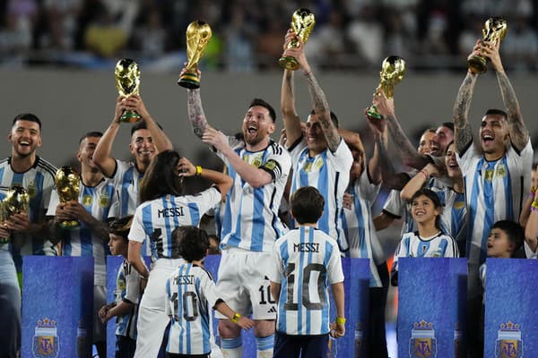 Hráč Lionel Messi z Argentíny drží repliku trofeje pre víťaza MS vo futbale počas osláv pre fanúšikov.