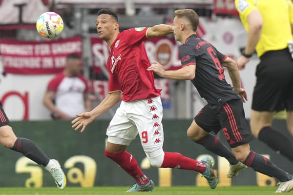 Hráč Mainzu Karim Onisiwo (vľavo) bojuje o loptu s Joshuom Kimmichom z Bayernu Mníchov