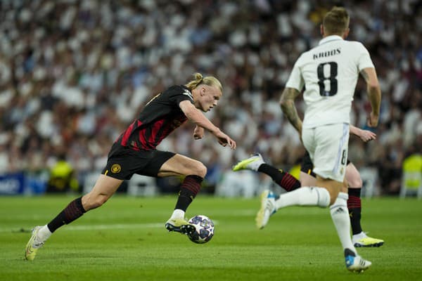 Hráč Manchesteru City Erling Haaland (vľavo) kontroluje loptu vo futbalovom zápase semifinále Ligy majstrov Real Madrid - Manchester City.