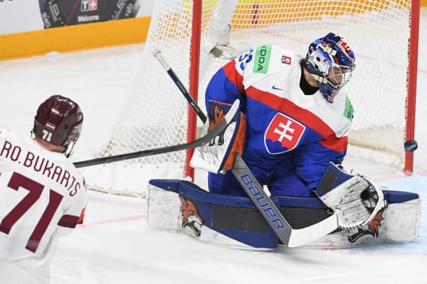 Zľava Roberts Bukarts (Lotyšsko) a brankár Stanislav Škorvánek (Slovensko) v zápase.