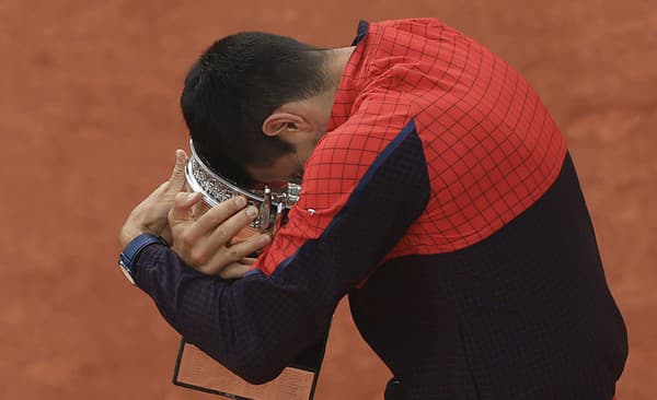 Srbský tenista Novak Djokovič objíma trofej.