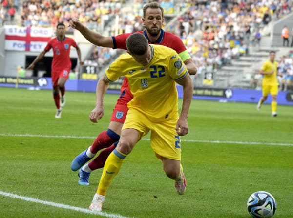 Anglický hráč Harry Kane (vzadu) bojuje o loptu s Ukrajincom Mykolom Matvienkom