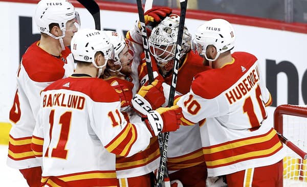 Mikael Backlund (vľavo) sa raduje so spoluhráčmi z tímu Calgary Flames.