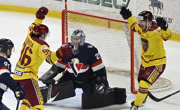 Zľava Marek Sloboda (HK Dukla Trenčín) oslavuje gól so spoluhráčom Róbertom Vargom (HK Dukla Trenčín) pred brankárom Samuelom Barošom (HC Slovan Bratislava).