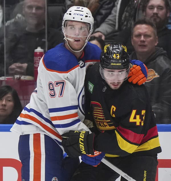 Connor McDavid (vľavo) bol v zápase s Vancouverom neustále atakovaný hráčmi súpera.