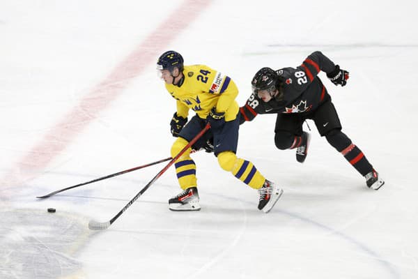 Na snímke švédsky hokejista Tom Willander (vľavo) a kanadský hokejista Conor Geekie.
