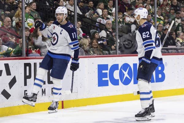 Center Adam Lowry z Winnipegu Jets sa raduje z gólu s Ninom Niederreiterom.