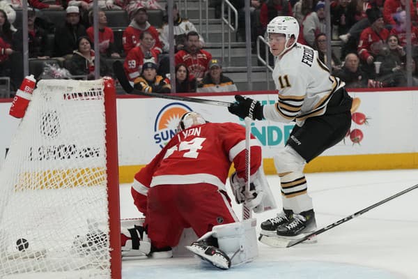 Center Trent Frederic z Bostonu Bruins strieľa na brankára Alexa Lyona z Detroitu Red Wings.