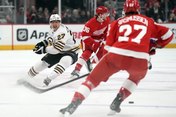 Obranca Hampus Lindholm (27) sleduje puk počas zápasu zámorskej NHL Detroit Red Wings - Boston Bruins.