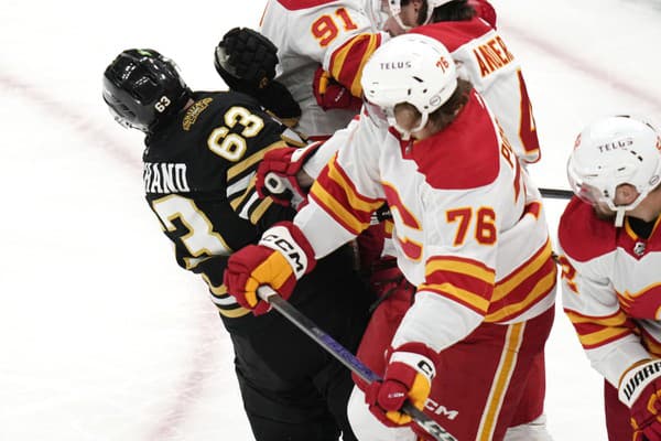 Martin Pospíšil (Calgary) tvrdo atakoval Brada Marchanda z Bostonu.