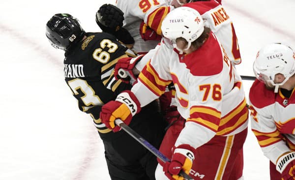 Martin Pospíšil (Calgary) tvrdo atakoval Brada Marchanda z Bostonu.