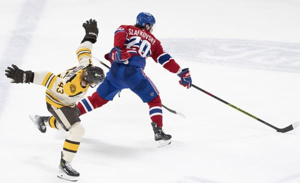 Juraj Slafkovský (Montreal) v súboji s Dantonom Heinenom (Boston)