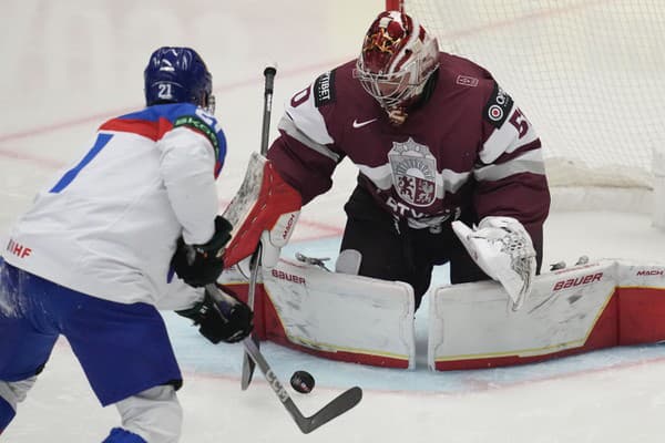 Lotyšský brankár Kristers Gudlevskis (vpravo) zachraňuje pred slovenským hráčom Milošom Kelemenom.