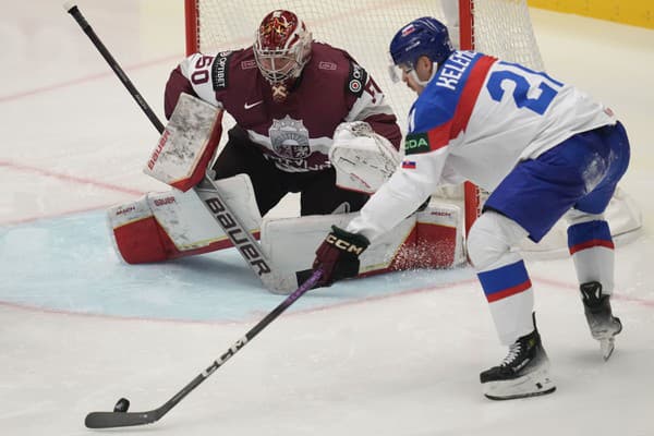 Lotyšský brankár Kristers Gudlevskis (vľavo) zachraňuje pred slovenským hráčom Milošom Kelemenom.