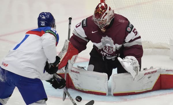 Lotyšský brankár Kristers Gudlevskis (vpravo) zachraňuje pred slovenským hráčom Milošom Kelemenom.