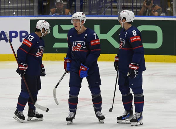 Americkí hokejisti zľava Johnny Gaudreau, kapitán Brady Tkachuk a Zach Werenski sa tešia z gólu.