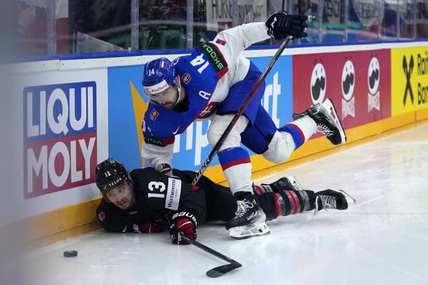 Slovenský hokejista Peter Čerešňák (vpravo) a hráč Kanady  Brandon Tanev bojujú o puk.