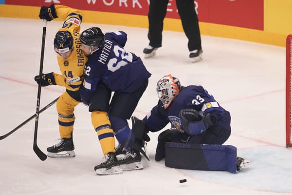 Fínsky brankár Emil Larmi (vpravo) bráni pred Švédom Joelom Eriksonom Ekom (vľavo) v zápase štvrťfinále Švédsko - Fínsko.