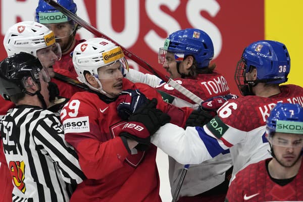 Českí (svetlé dresy) a švajčiarski hokejisti sa bijú.