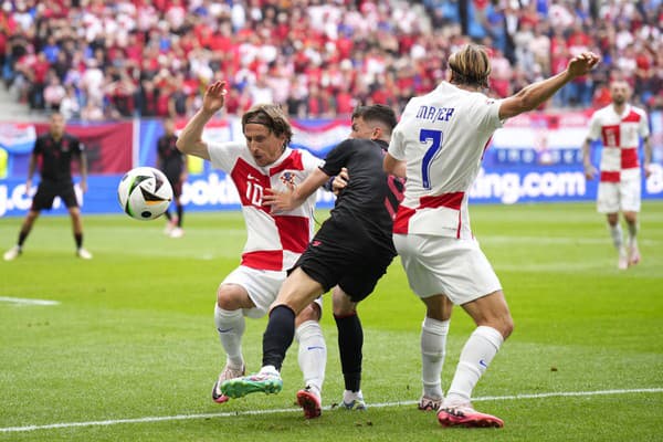 Chorvátski hráči Luka Modrič(vľavo) a Lovro Majer (vpravo) v súboji s Albáncom Jasirom Asanim (uprostred) počas zápasu.