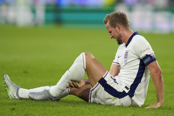 Kapitán Anglicka Harry Kane sedí na trávniku.