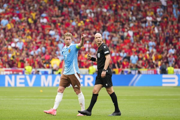 Belgický futbalista Kevin De Bruyne a rozhodca Anthony Taylor.