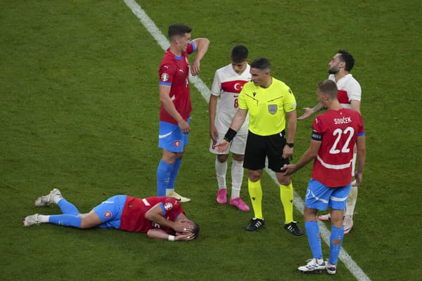 Český futbalista Vladimír Coufal leží zranený na zemi.