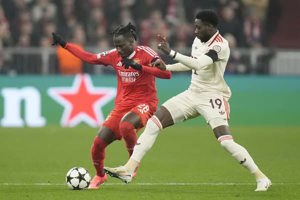 Hráč Bayernu Alphonso Davies  (vpravo) bojuje o loptu s Issom Kaboreom z Benficy.