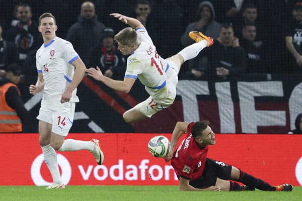 Český futbalista Lukáš Červ skáča nad hráčom Kristjanom Asllanim z Albánska počas zápasu.