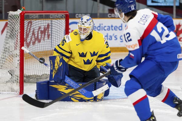  Brankár Švédska Melker Thelin a hokejista Slovenska Peter Císar počas zápasu základnej B-skupiny Slovensko - Švédsko. 