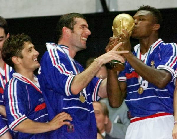 Francúz Marcel Desailly (vpravo) bozkáva trofej. Uprostred Zinedine Zidane a Bixente Lizarazu vpravo sa prizerajú.