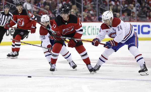 Slovenský obranca Šimon Nemec (17) z New Jersey Devils a hráči Montrealu Canadiens Juraj Slafkovský (vľavo).