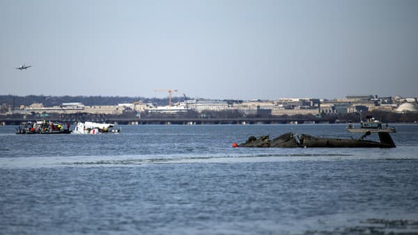 Na snímke, ktorú poskytla americká pobrežná stráž, posádka na zásahovom člne zabezpečuje bezpečnostnú zónu okolo vraku havarovaného lietadla na rieke Potomac vo Washingtone.