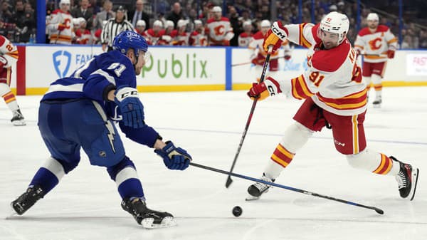 Erik Černák (Tampa Bay) pri bránení útočníka Calgary Nazema Kadriho.