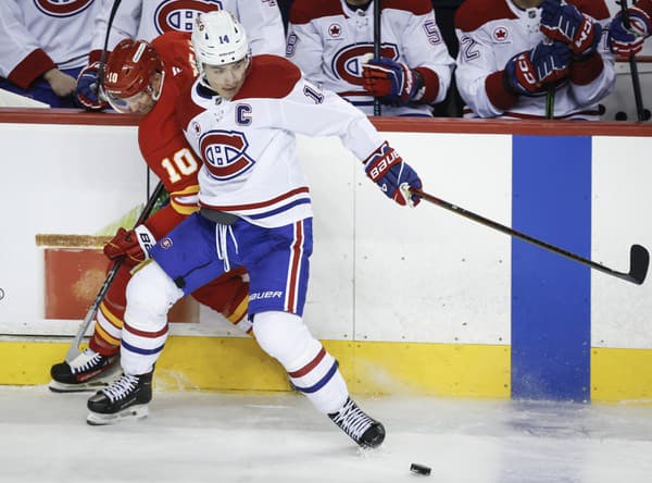 Nick Suzuki z Montreal Canadiens (vpravo) atakuje Jonathana Huberdeaua z Calgary Flames.







