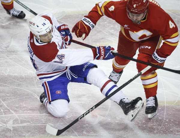 Nick Suzuki z Montreal Canadiens (vľavo) je atakovaný Rasmusom Anderssonom z Calgary Flames.







