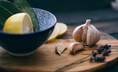 Food styling set with garlic, lemon and lavender on wooden textured cutting board