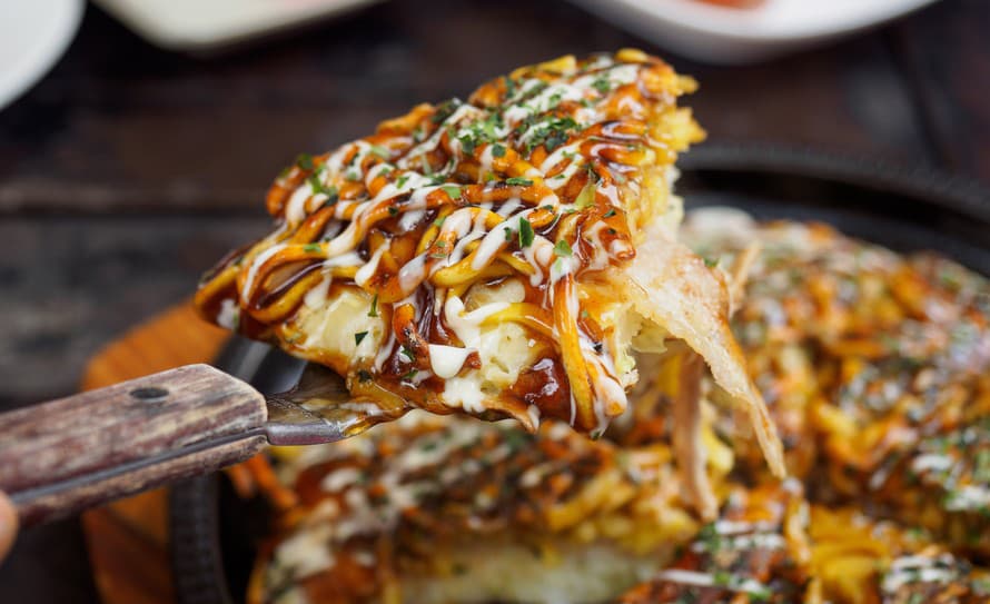 K tradičným jedlám kuchyne Krajiny vychádzajúceho slnka patrí aj kapustová placka okonomiyaki. 