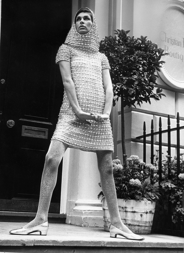 25. januára 1960 – Londýn, Anglicko, Spojené kráľovstvo – modelka v šatke a minisukni pred butikom Christian Dior.