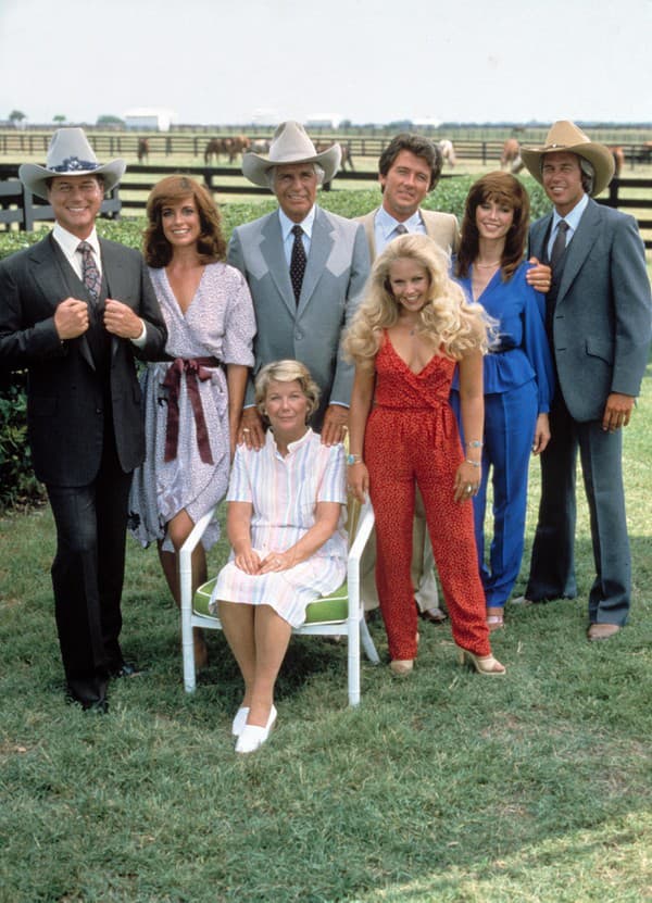 Herci zo seriálu Dallas. Charlene je v červenom overale vpravo dole.